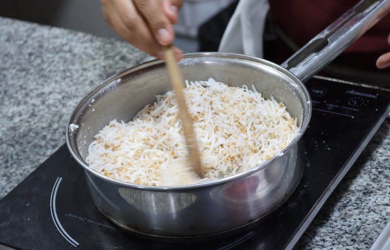 Preparando coco garrapinado en una sartén