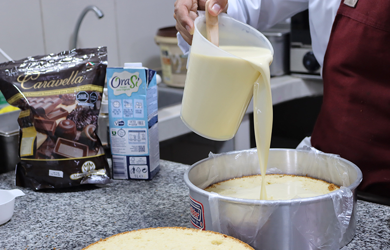 Aplicando en un bizcochuelo el jarabe calda delicia